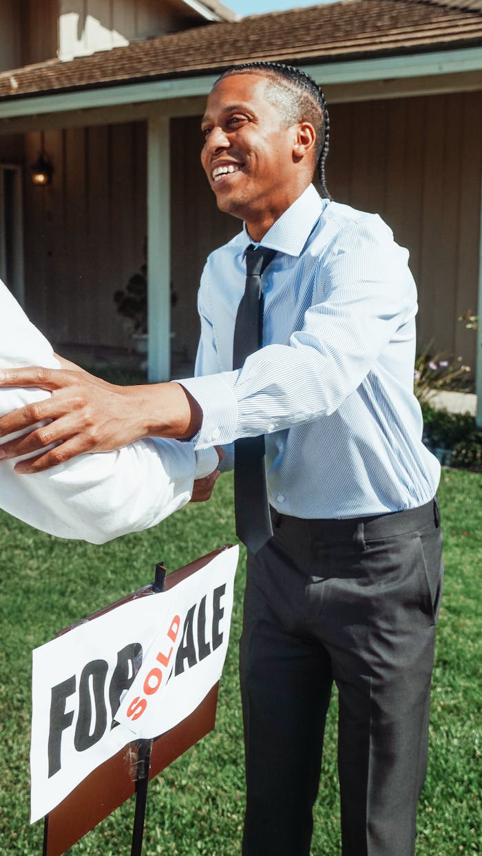 Home Man shaking hands outside a house with a